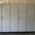 Professionally installed white garage cabinets, closed doors