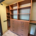 Brown hallway closet shelves, coat hangers and drawers