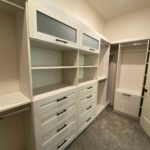 Custom rustic walk-in closet with shelves, coat hanging space and drawers