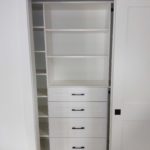 Reach-in closet with drawers and shelves
