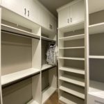 Custom white shelves, cabinets and coat rods