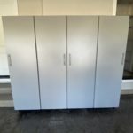 Tall grey garage storage cabinets with doors closed in garage