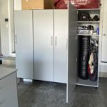 Tall grey garage storage cabinets in a garage storing golf clubs