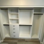 White hallway closet shelves, coat hangers and drawers