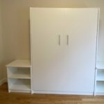 Closed white murphy bed storage unit in a bedroom