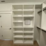 Custom white walk-in closet with shelves and coat hanging space