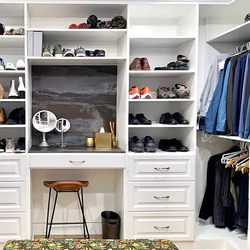 Custom walk-in closet with a built-in vanity and shoe shelving