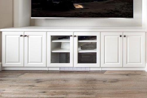 White media center cabinets with glass-front doors and drawer fronts