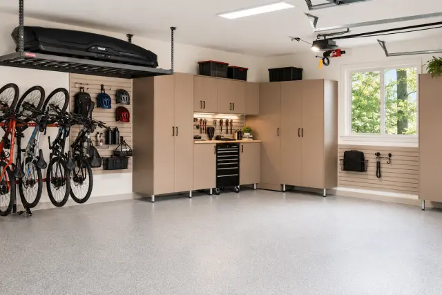 Beige garage cabinets with overhead storage and a wall-mounted bike rack